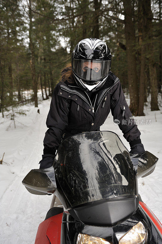 女人在雪地摩托上戴着头盔