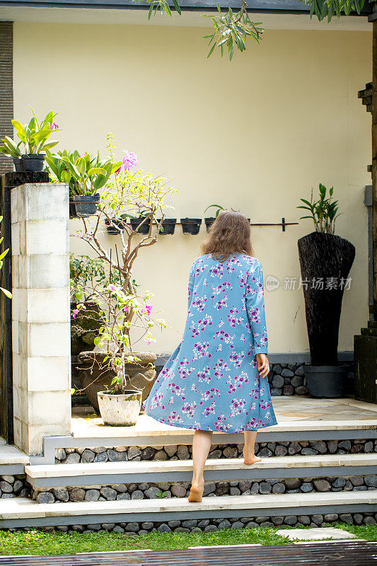 夏天爬上露台台阶的女人