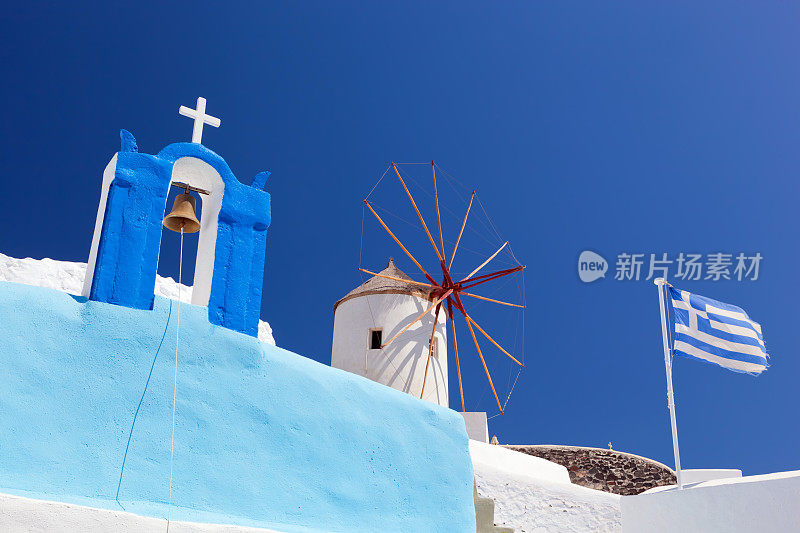 希腊圣托里尼岛的伊亚镇。著名的风车、教堂、旗帜。