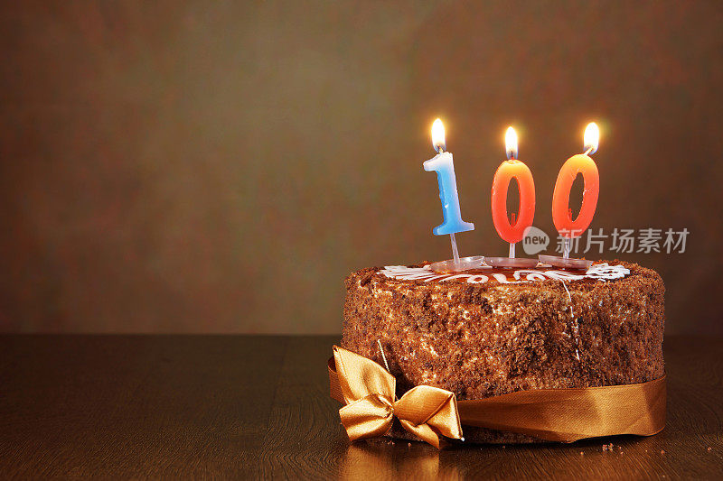 生日巧克力蛋糕和燃烧的蜡烛作为第100个
