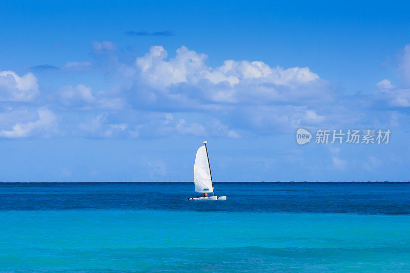 帆船航行在加勒比海的蓝色的水与蓝天的背景，坎昆，墨西哥。