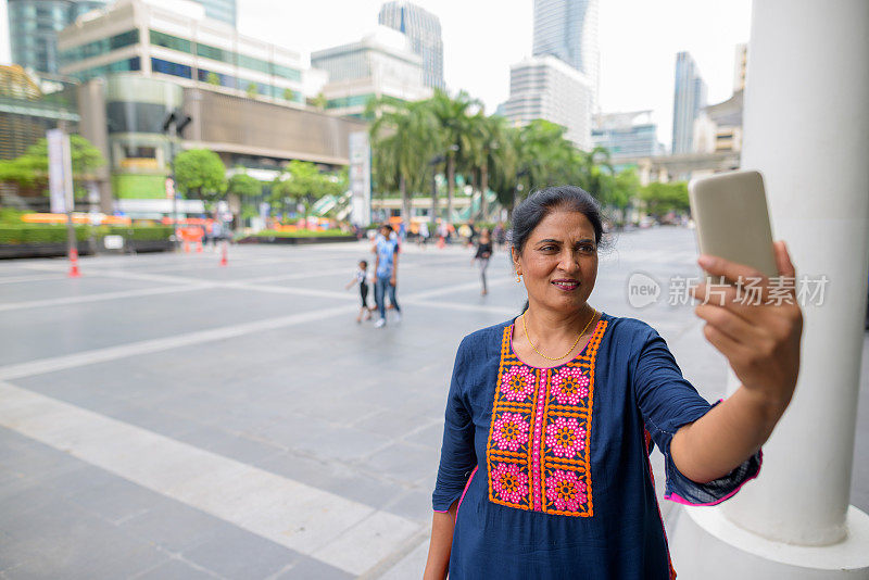 成熟美丽的印度女人的肖像放松在泰国曼谷暹罗广场购物中心