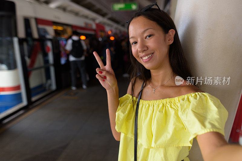 年轻美丽的多民族游客女子肖像在BTS空中火车站在泰国曼谷