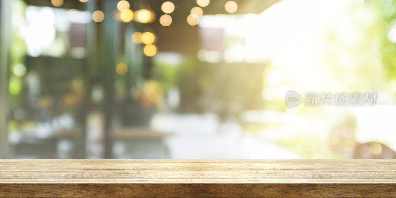 空的木制桌面与模糊的咖啡馆或餐厅内部背景，全景横幅。抽象背景可以用来展示产品。