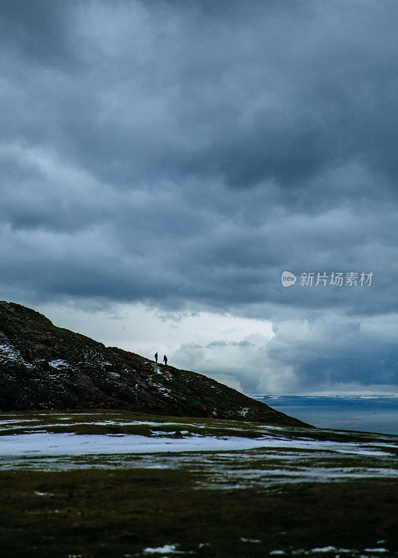 人们在暴风雨天气下在美丽的冬季山脉徒步旅行