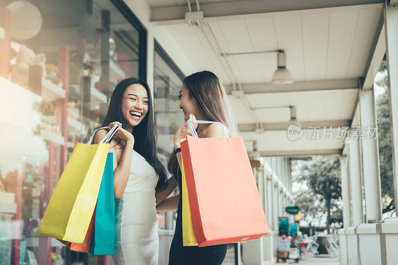 两个人亚洲女人有趣和快乐的购物在一起的outlet。