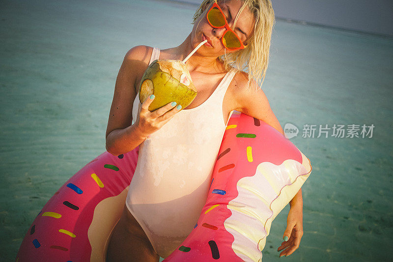 热女人喝椰子汁旁边的海洋，马尔代夫