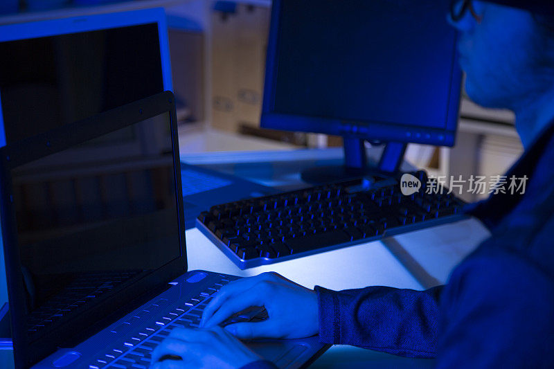 电脑黑客或程序员利用笔记本电脑进行网络攻击。