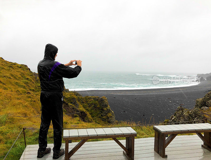 冰岛，Snaefellsnes:游客在雨天Djúpalónssandur秋季黑海滩