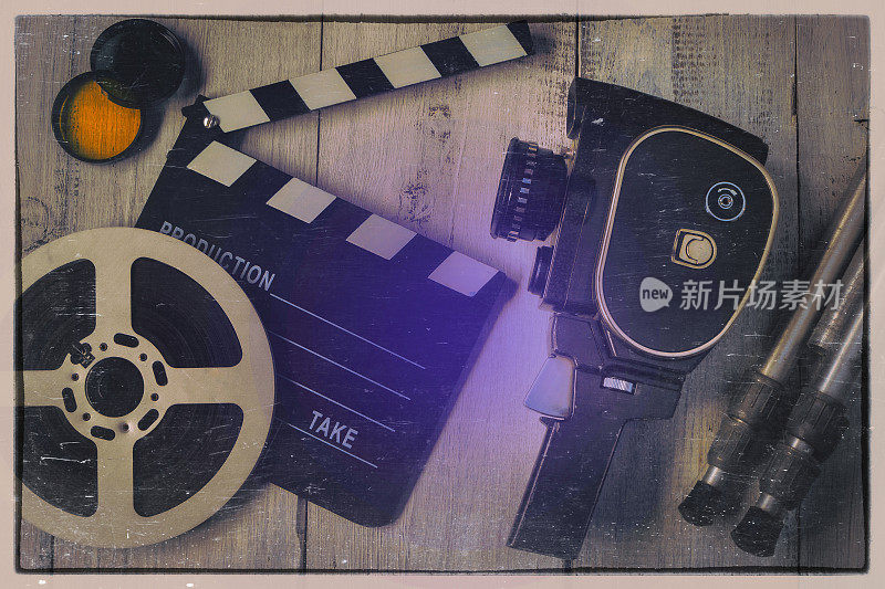 旧的电影摄影机、拍板和胶卷在卷轴上