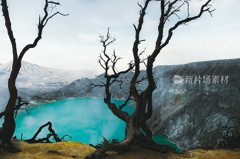 印度尼西亚东爪哇的伊真火山火山口的绿松石色湖泊，山脉和硫磺蒸汽的戏剧性景色