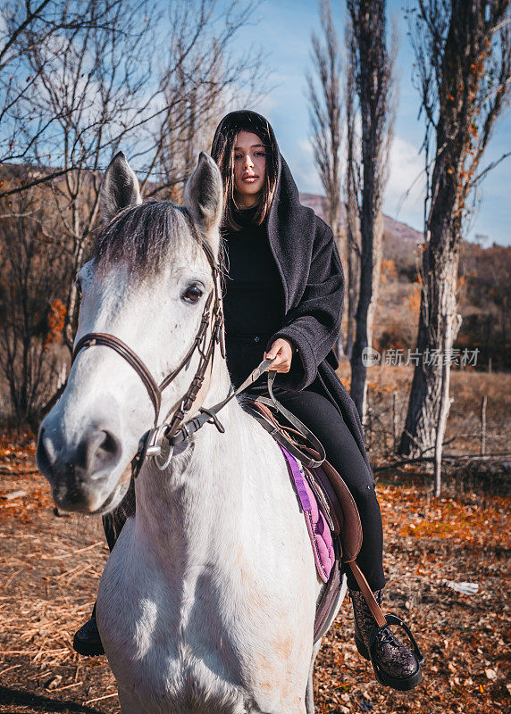 在一个阳光明媚的日子里，一个女人牵着一匹马在牧场上