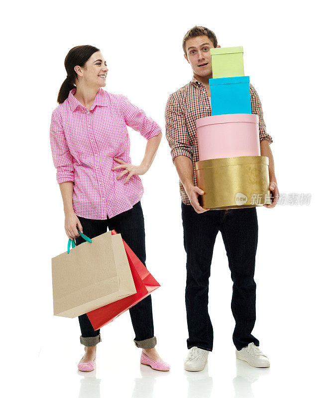 白人妻子购物狂穿着牛仔裤拿着包站在白色背景前