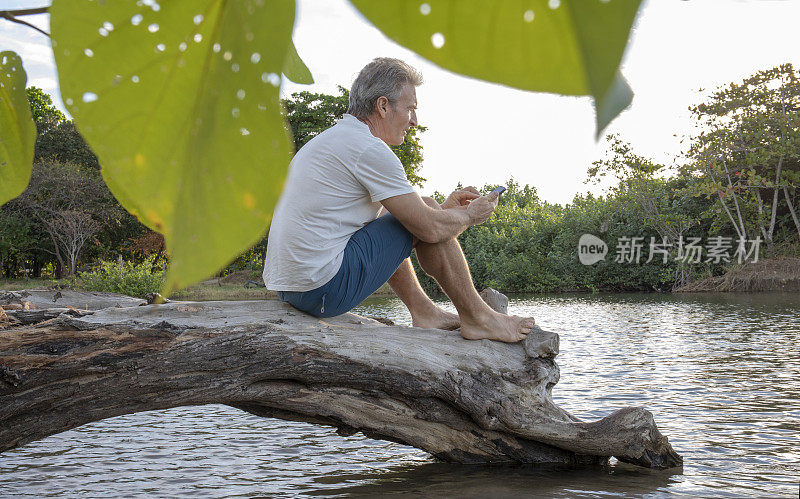 男子站在浅水中的木头上休息