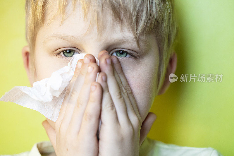 一个生病的男孩在擦鼻子