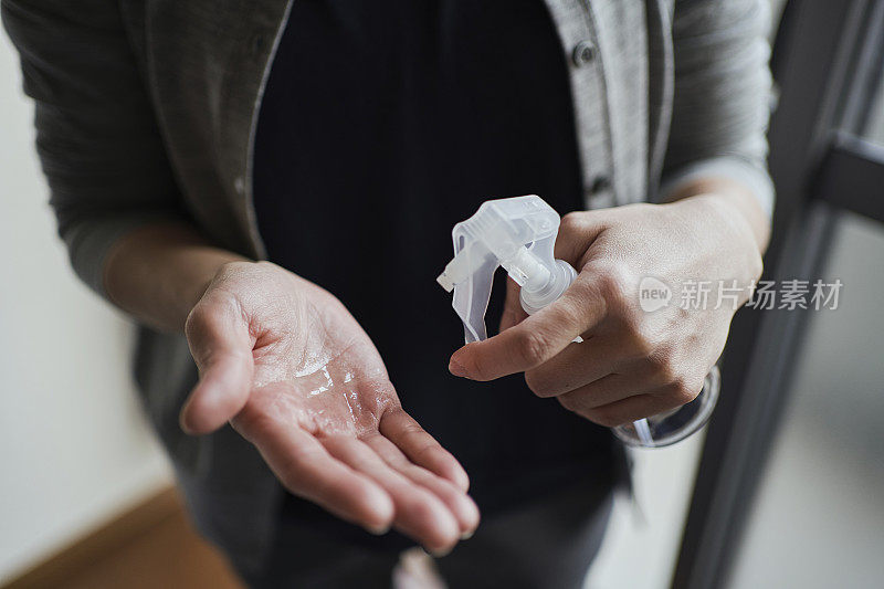 妇女在家用酒精消毒双手