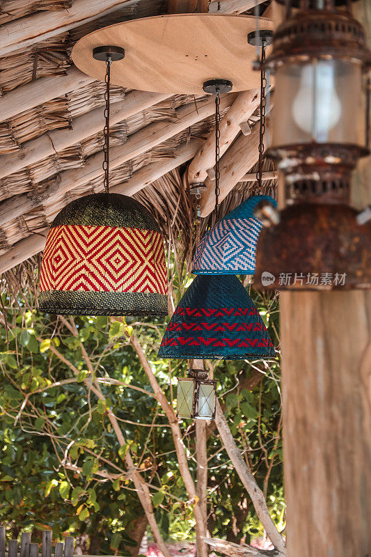 波希米亚灯悬挂在热带浮木屋顶