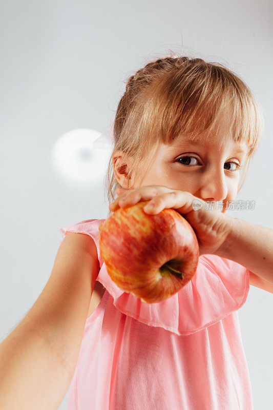 小女孩拿着苹果的肖像