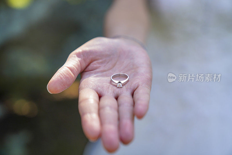 新娘手上拿着结婚戒指。婚礼概念和婚纱