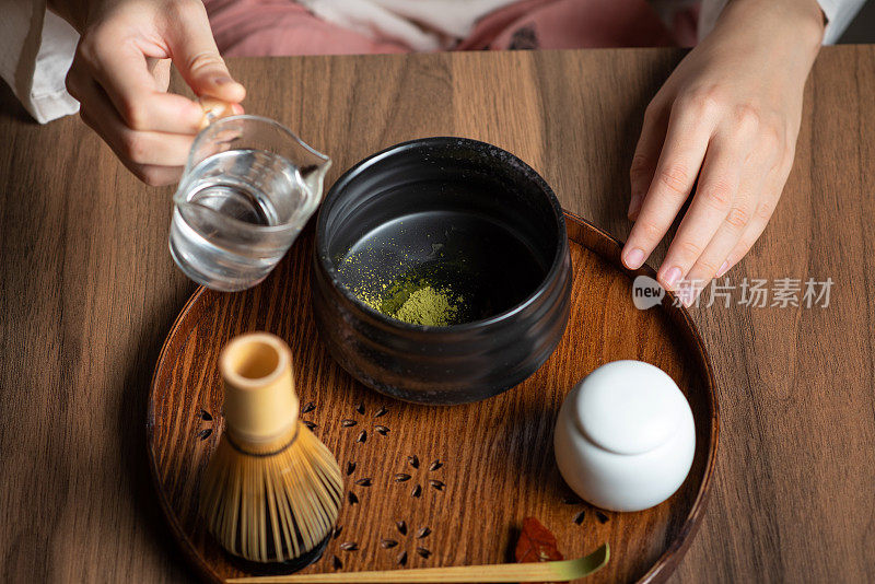 女子加入热水，制作抹茶绿茶与传统配件为日本茶道