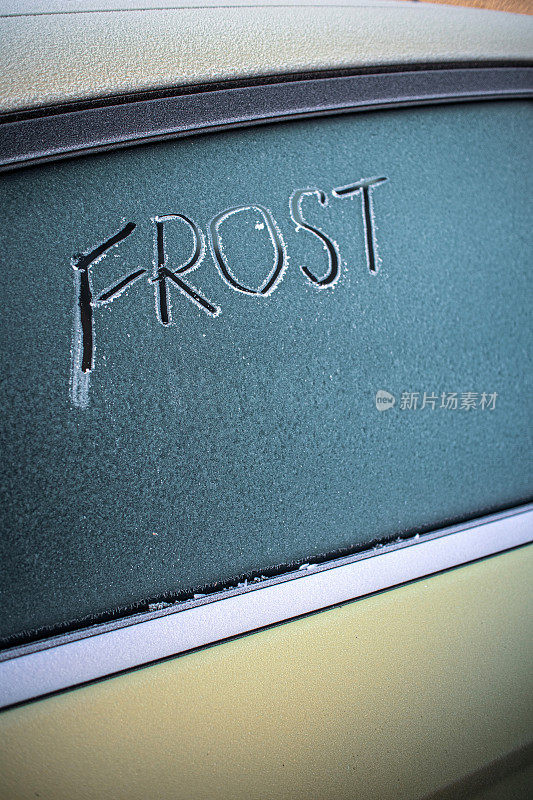 在一辆结霜的汽车挡风玻璃上，手写着“FROST”(霜冻)一词