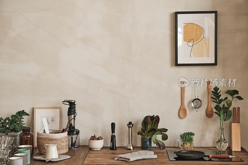 舒适的厨房内部与抽象图画和器皿在墙上，厨房设备和柜台上的陶器