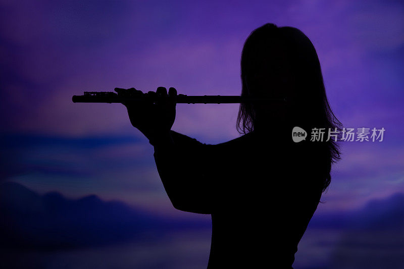 紫色天空上一个吹着长笛的女人的黑色剪影。