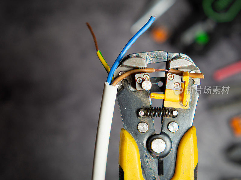 电工用剥线钳剥电线。