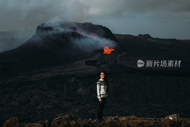 在冰岛Fagradalsfjall火山喷发时，一名妇女感到敬畏