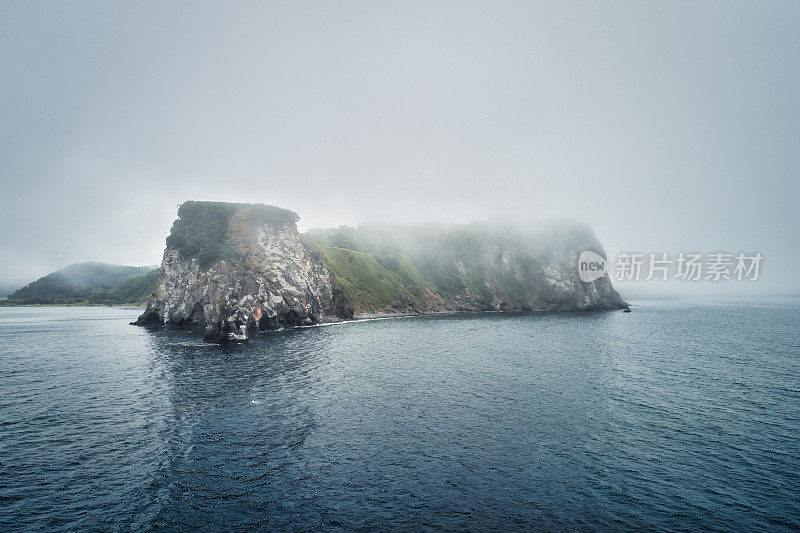 雾中的阿瓦查湾海岸岩石