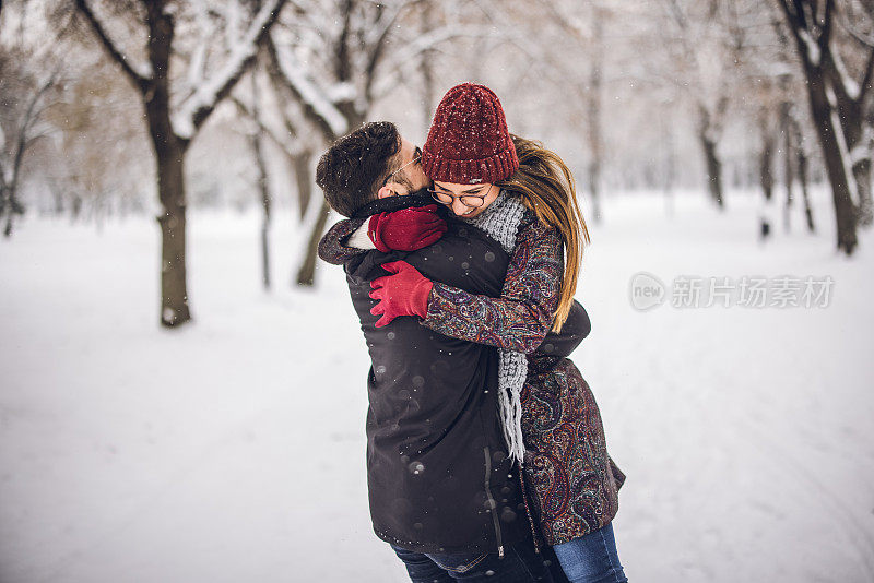 冬日里，一对年轻夫妇在公园里互相拥抱