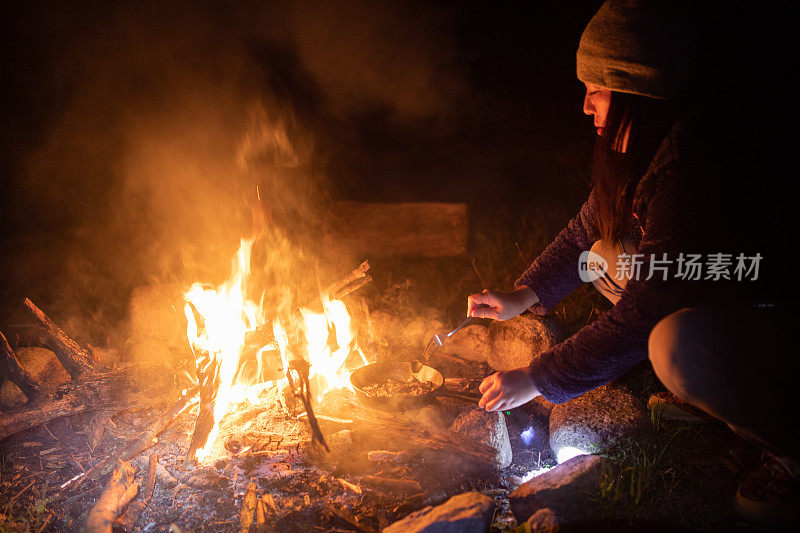 女营员在露天营火上做饭