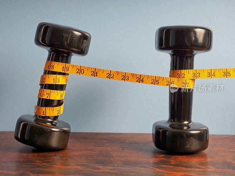 自由重量和卷尺，一个测量健身和减肥进展的概念形象
