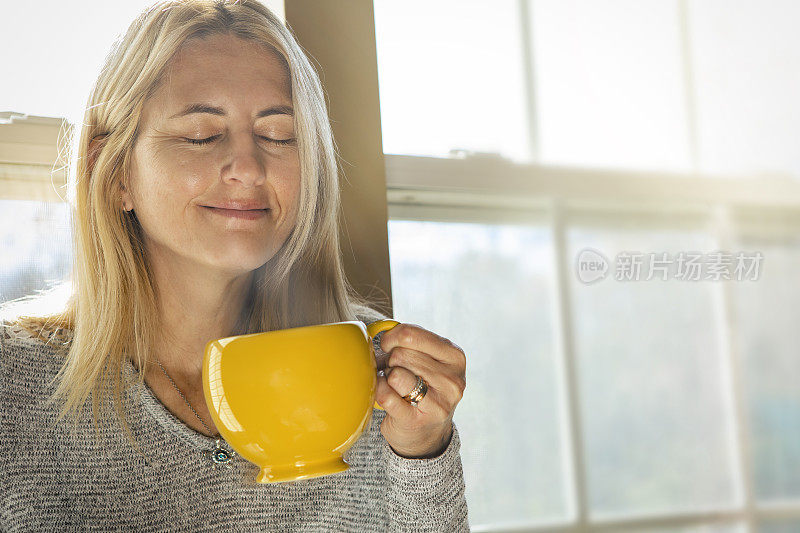 快乐女人闻到早上的咖啡