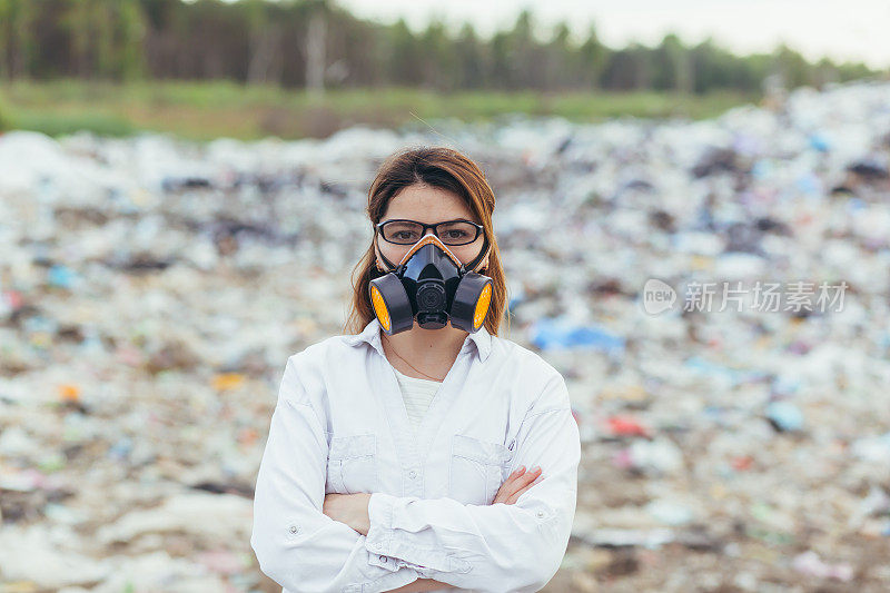 在垃圾填埋场，戴着防护口罩的女科学家正在评估环境污染程度