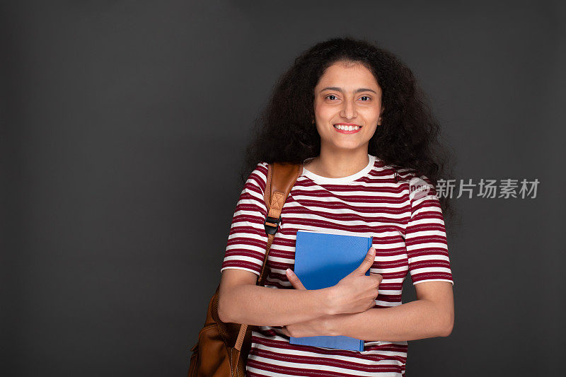 年轻女孩学生的肖像持有笔记本和有背包库存的图像