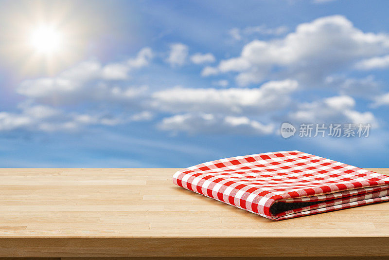 空桌子，折叠的野餐毯子，蔚蓝的天空