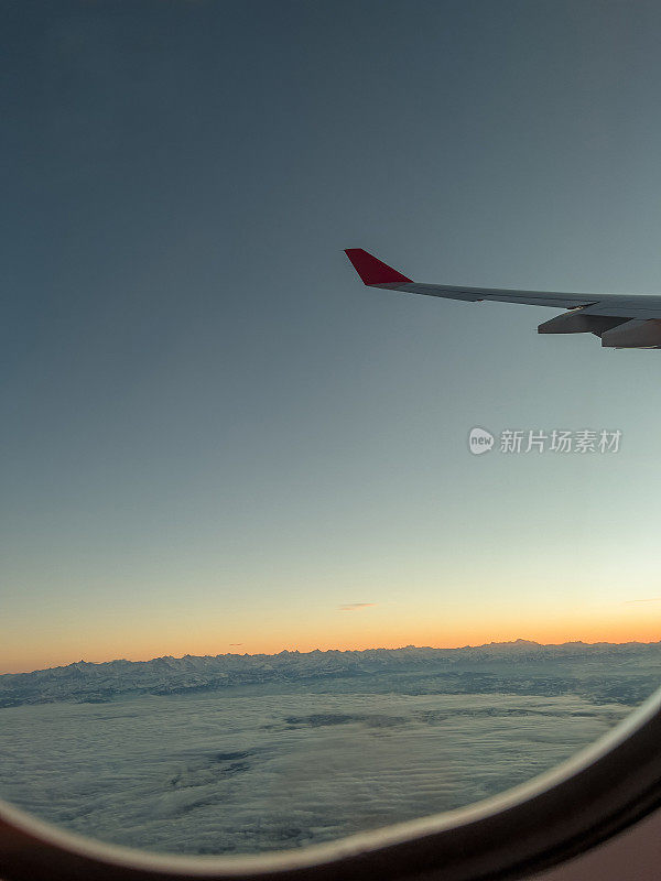 从飞机窗口往外看，美丽的日出在空中