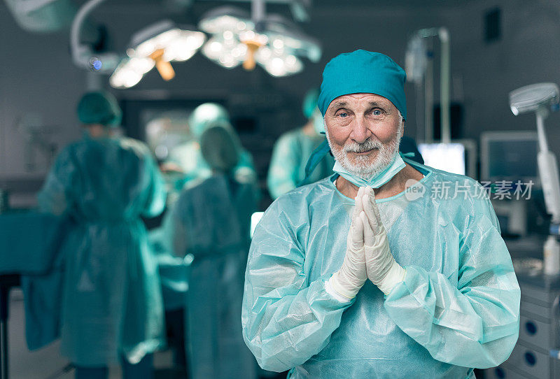 老年外科医生在手术室祈祷
