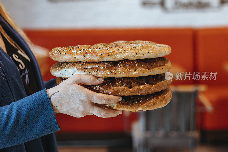 那个女人从烤箱里买了新鲜的皮塔饼，那个女人有皮塔面包，斋月皮塔饼