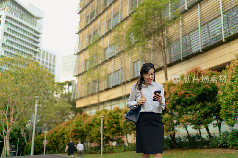 亚洲女性在城市背景下使用手机