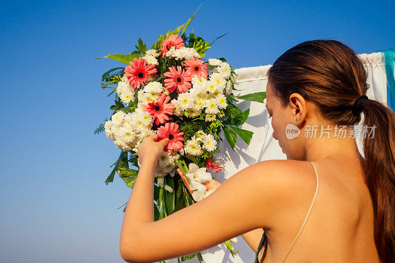 装饰工作与花组成婚礼拱门在海洋海滩