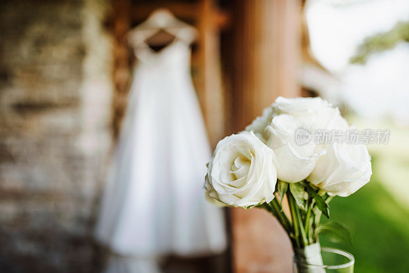 背景是精致美丽的婚礼花束和婚纱。