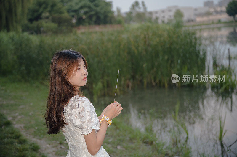 亚洲女孩在晚上燃放烟花