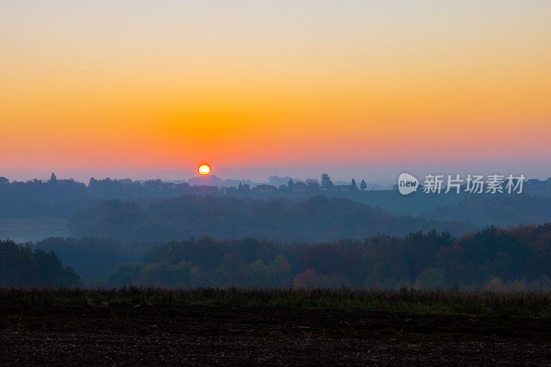 大雾天气下，森林和乡村的落日美景