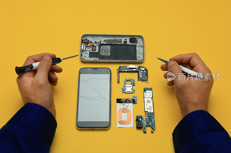 上图为黄色背景，男子正在修理坏掉的智能手机