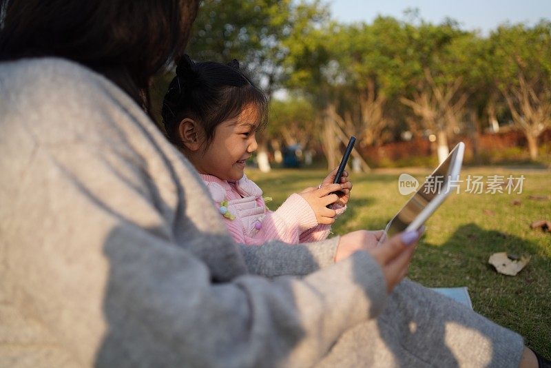 亚洲小女孩和妈妈使用智能设备