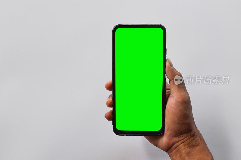 模拟手机。男子手持垂直位置的黑色智能手机，屏幕为绿色