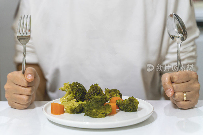 一个不想节食的女人。这位女士不想吃煮西兰花。