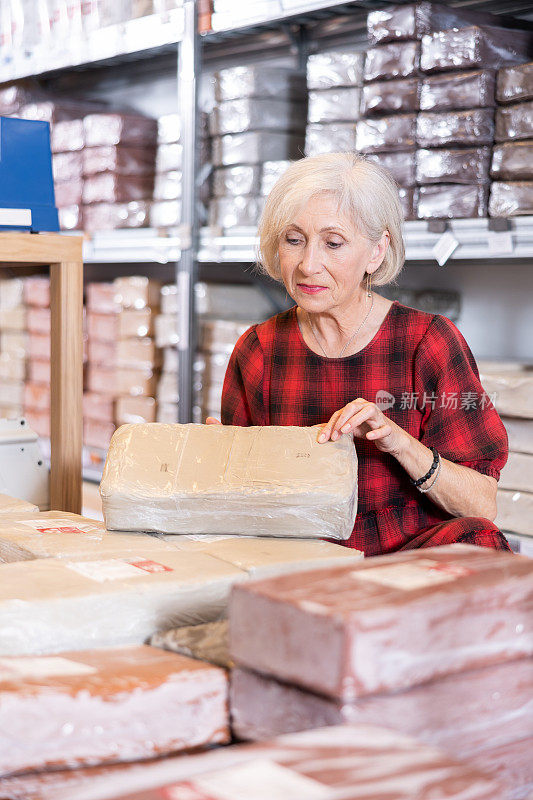一位老妇人在专门的商店里仔细挑选用白粘土制成的蜂窝煤